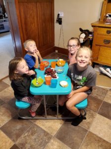 The four older kids eating their soup.